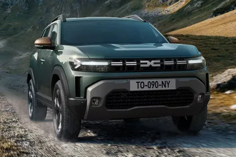 Automobil Dacia pe un drum montan, evidențiind designul robust și modern.