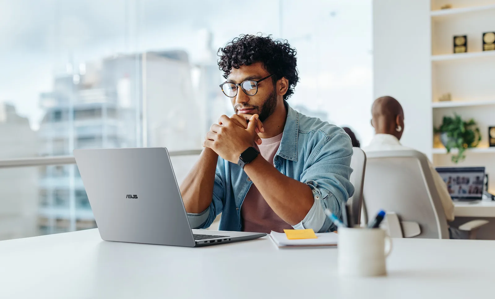 Un profesionist lucrează la un laptop ASUS într-un mediu de birou modern.