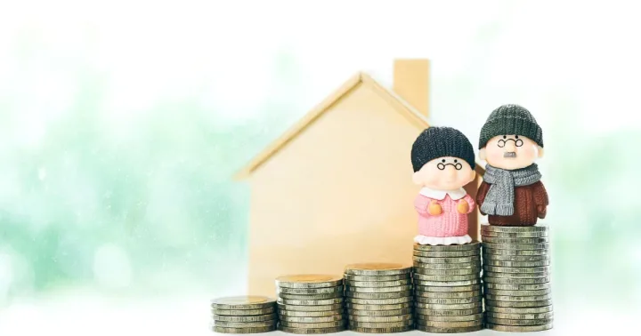 Pensionarii stau lângă monede, simbolizând economiile pentru viitor.