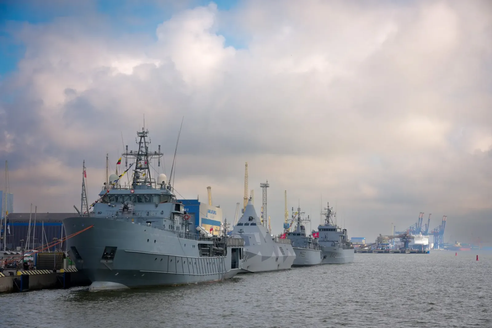 Nave militare ancorate într-un port, pregătite pentru misiuni de securitate.