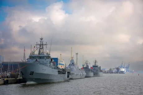 Nave militare ancorate într-un port, pregătite pentru misiuni de securitate.