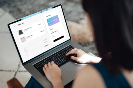 O persoană folosește un laptop pentru a face cumpărături online.