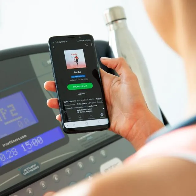 Utilizator ascultând muzică pe Spotify în timpul antrenamentului la sală.