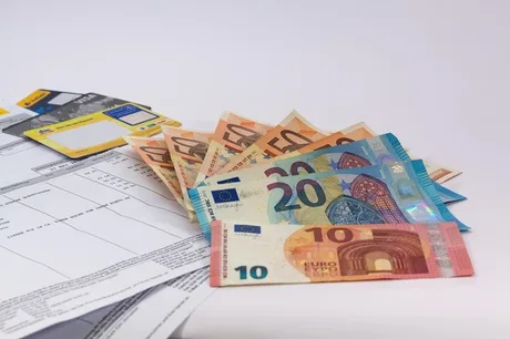 Bancnote euro și documente financiare pe un fundal alb.