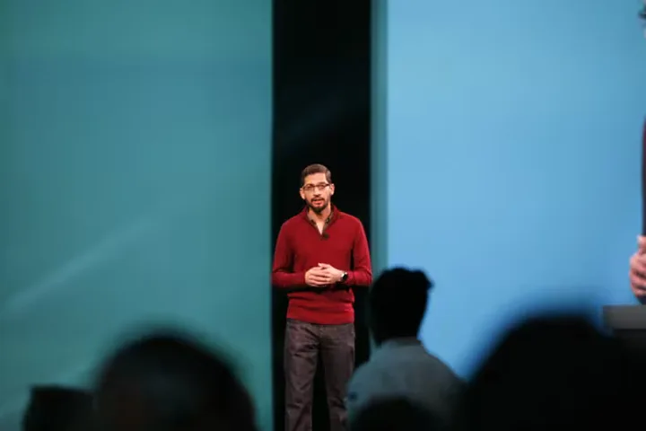 Prezentare a unui lider în tehnologie pe scenă, discutând despre inteligența artificială.