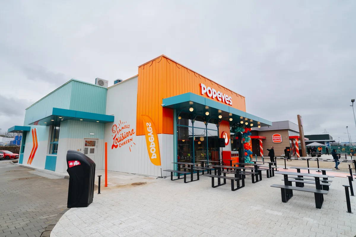 Fațada restaurantului Popeyes, colorată și atrăgătoare.
