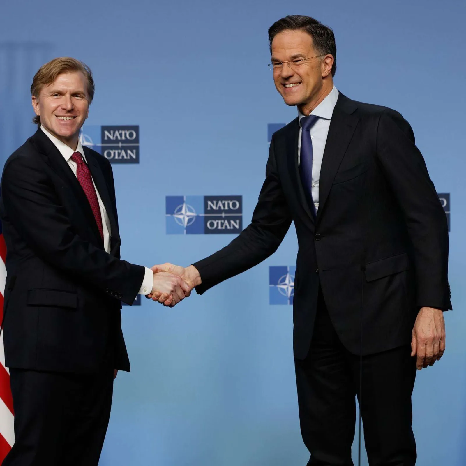 Reprezentanți ai NATO discutând despre contribuțiile financiare ale europenilor.