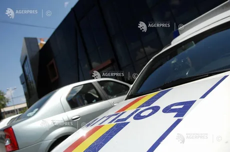 Mașină de poliție parcată în fața unui clădiri moderne din București.