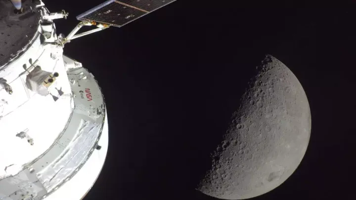 Vedere a Lunii și a unei nave spațiale în apropiere, simbolizând explorarea cosmică.