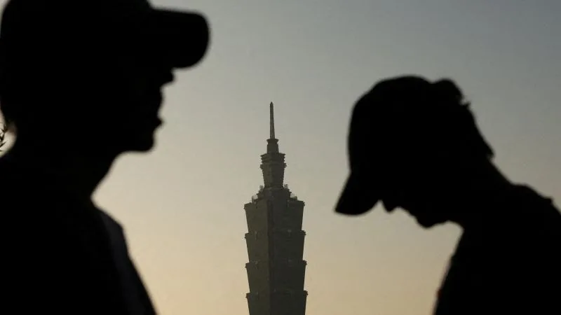 Silhouette de persoane cu Turnul Taipei în fundal la apus.