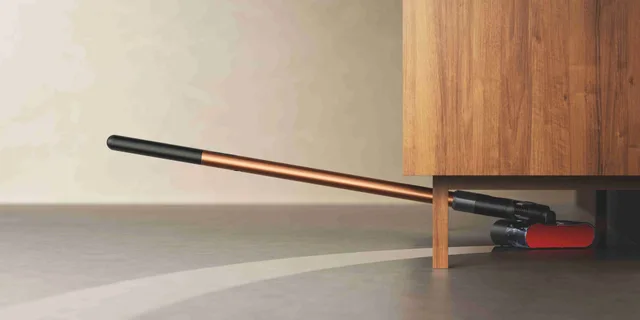 Aspiratorul PencilWash curățând sub un mobilier jos, demonstrând flexibilitatea.