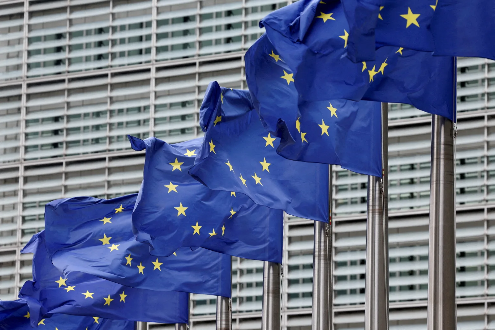 Steaguri ale Uniunii Europene fluturând în fața clădirii Comisiei Europene.