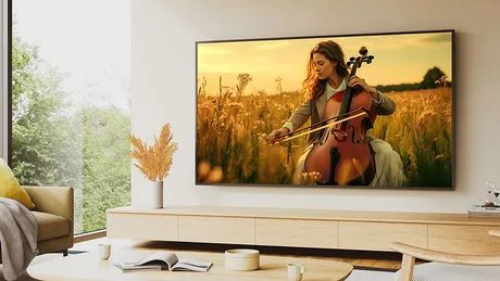 Televizor Bravia cu o femeie care cântă la violoncel într-un peisaj de câmp.