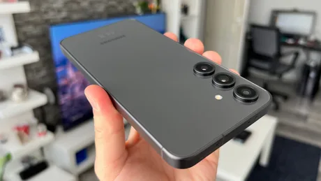 Un smartphone Samsung cu trei camere, pe fundal modern.