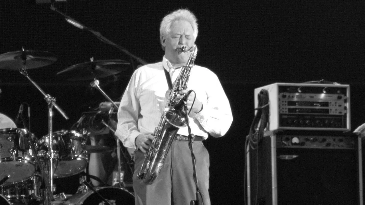 Saxofonistul Dick Parry cântând pe scenă, aducând un omagiu muzicii.