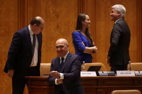Premierul Ilie Bolojan discutând despre moțiunea de cenzură în Parlament.