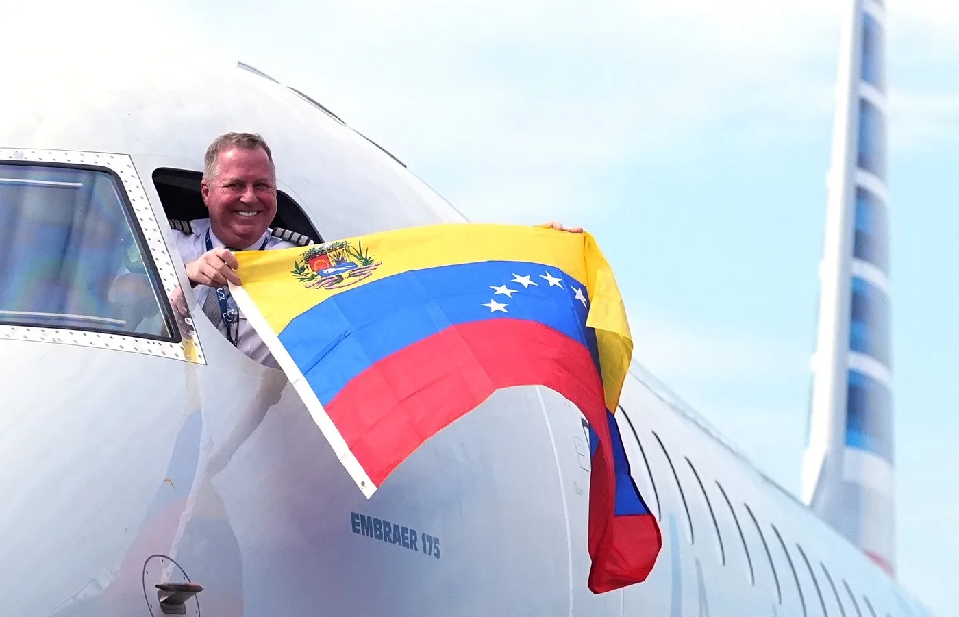 Pilotul salută cu steagul Venezuelei la sosirea zborului din Miami.