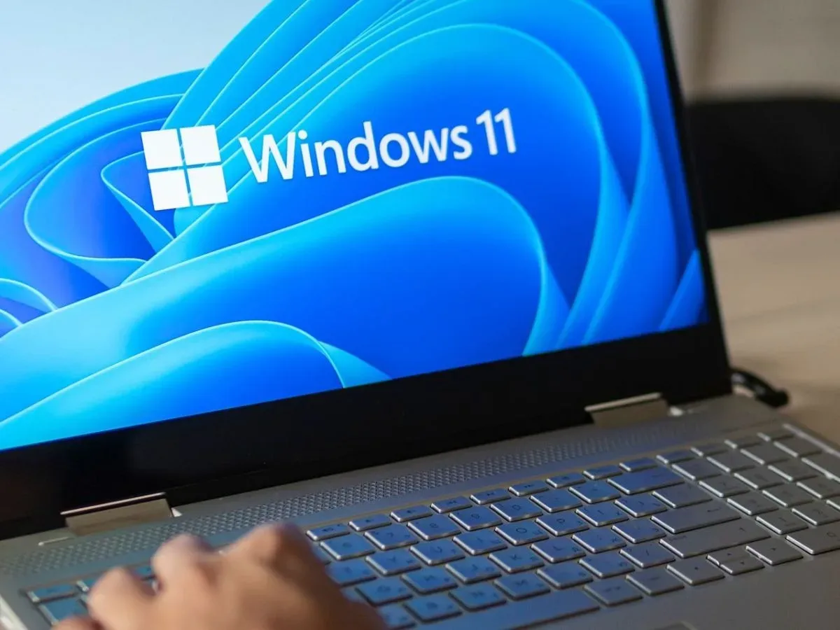 Ecran Windows 11 pe un laptop, utilizator la tastatură.