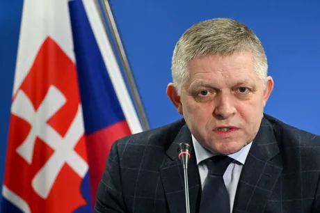 Robert Fico discutând despre conducta Drujba în fața steagului slovac.