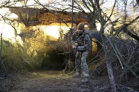 Soldat ucrainean pregătind echipamente în teren accidentat.