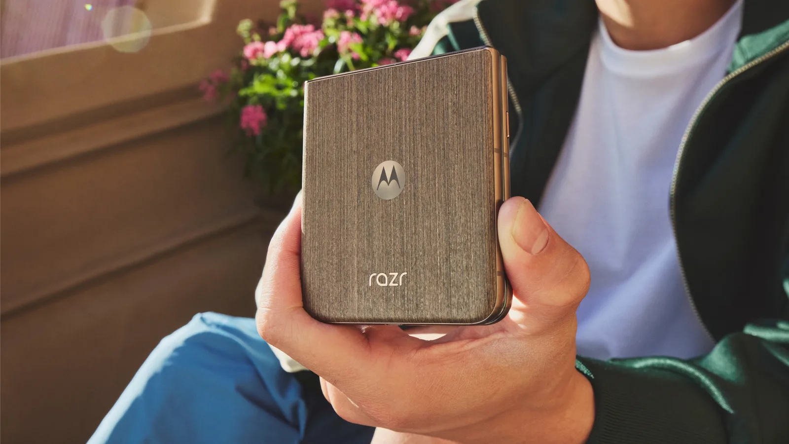 Un utilizator ține un telefon Motorola Razr în mână, într-un mediu relaxat.