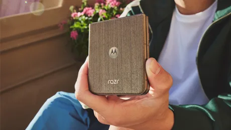 Un utilizator ține un telefon Motorola Razr în mână, într-un mediu relaxat.