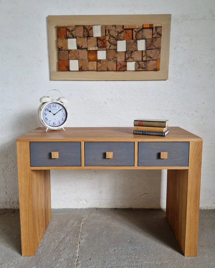 Birou din lemn cu sertare, decorat cu cărți și un ceas.