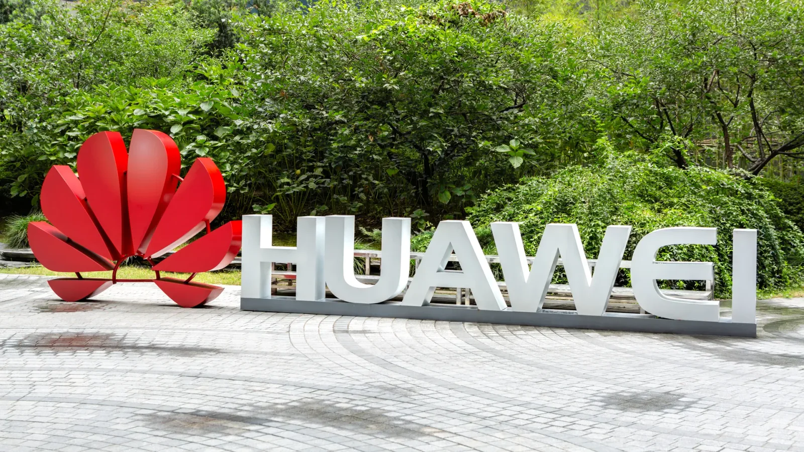 Logo-ul Huawei într-un peisaj verde, simbolizând inovația tehnologică.