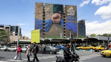 O stradă din Iran cu un panou publicitar mare și trafic urban.