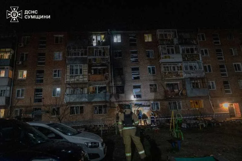Clădire avariată după atacuri cu drone în Ucraina, cu echipaje de intervenție la fața locului.