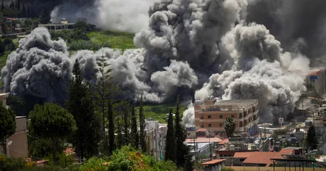 Fum dens se ridică deasupra unei zone afectate de conflicte.