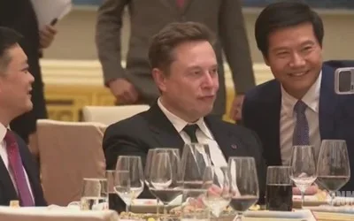 Lei Jun și Elon Musk zâmbesc într-un selfie la un dineu oficial.