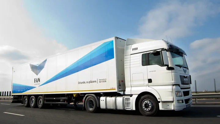 Camion FAN Courier pe autostradă, transportând colete pentru livrare.