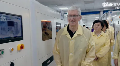 Tim Cook vizitând o facilitate de producție, îmbrăcat în echipament de protecție.