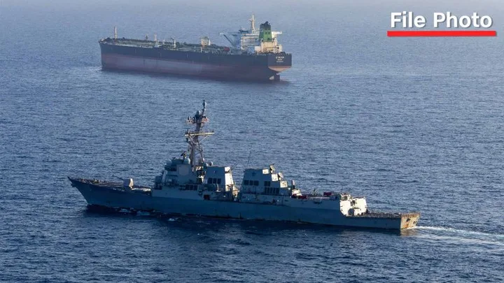 Nava militară americană navighează în apropierea unui petrolier în Strâmtoarea Hormuz.