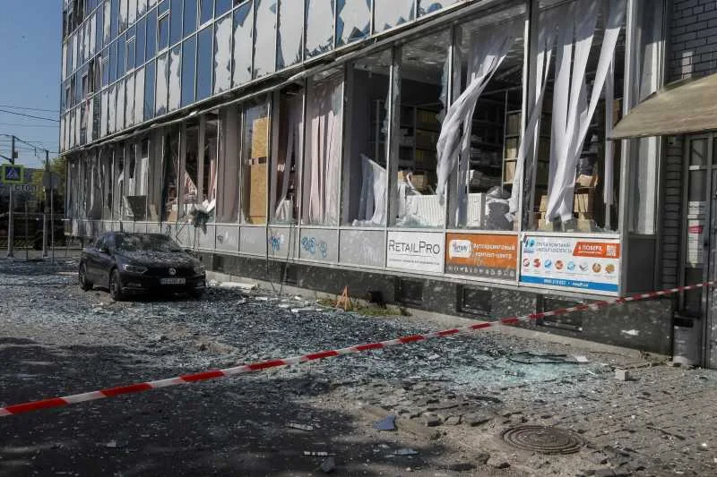 Clădire avariată de atacuri, sticlă spartă și distrugeri vizibile.