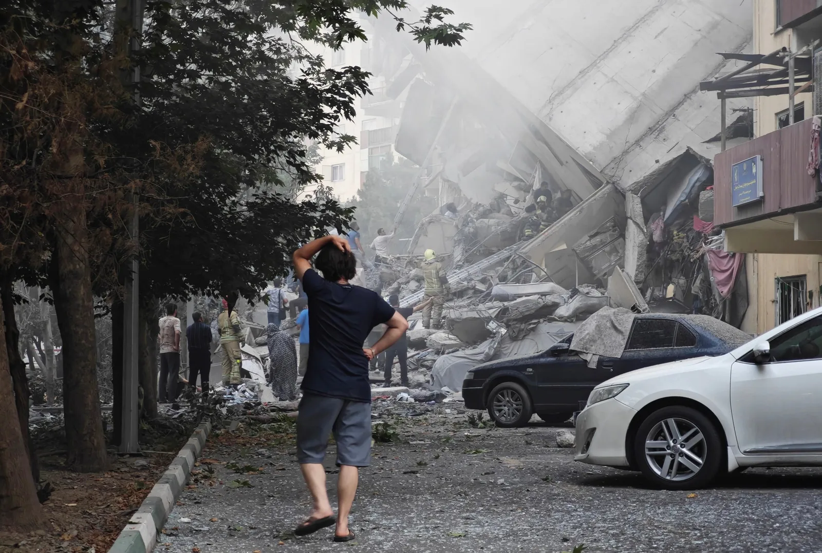 O persoană observă distrugerea unui imobil după un atac aerian devastator.