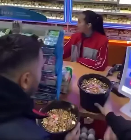 Un șofer aduce găleți pline cu monede la casă pentru a plăti combustibilul.