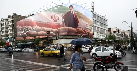 O stradă din Iran cu un panou publicitar mare și ploaie ușoară.