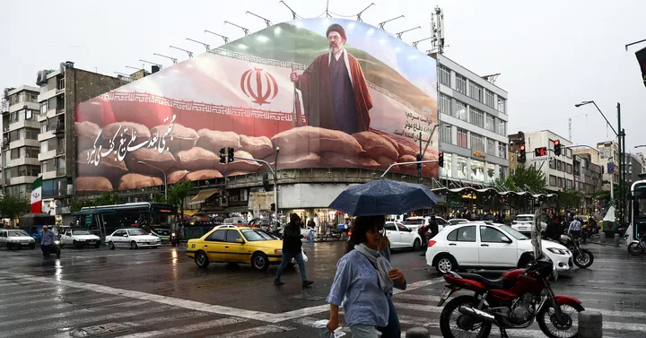 O stradă din Iran cu un panou publicitar mare și ploaie ușoară.