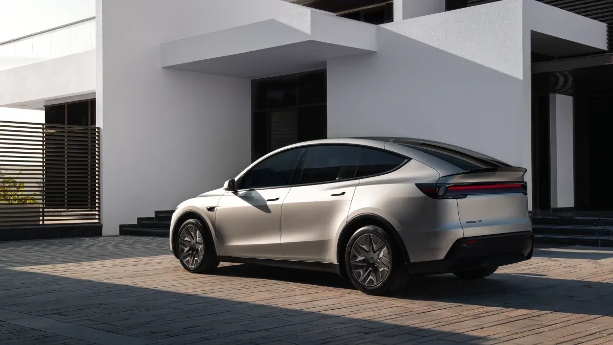 Tesla Model Y parcat în fața unei clădiri moderne.