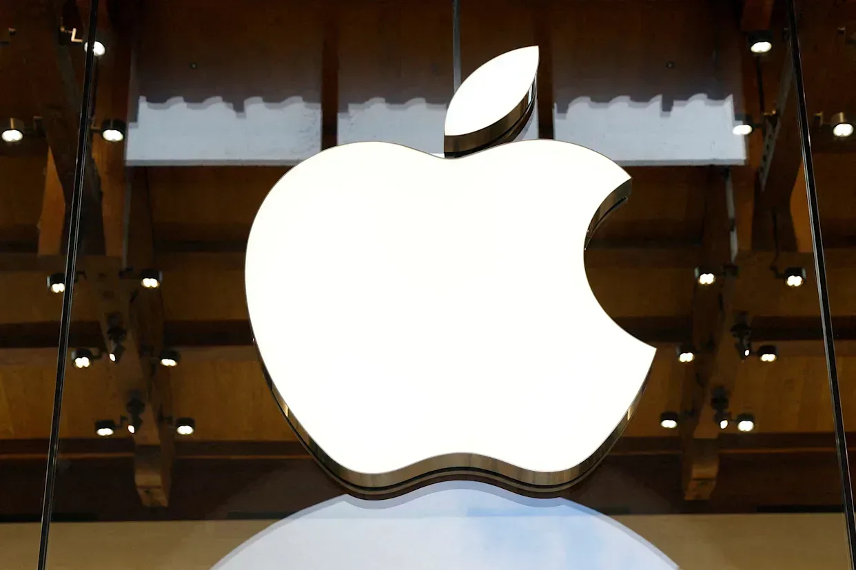 Logo-ul Apple reflectat pe o suprafață lucioasă, simbol al inovației tehnologice.
