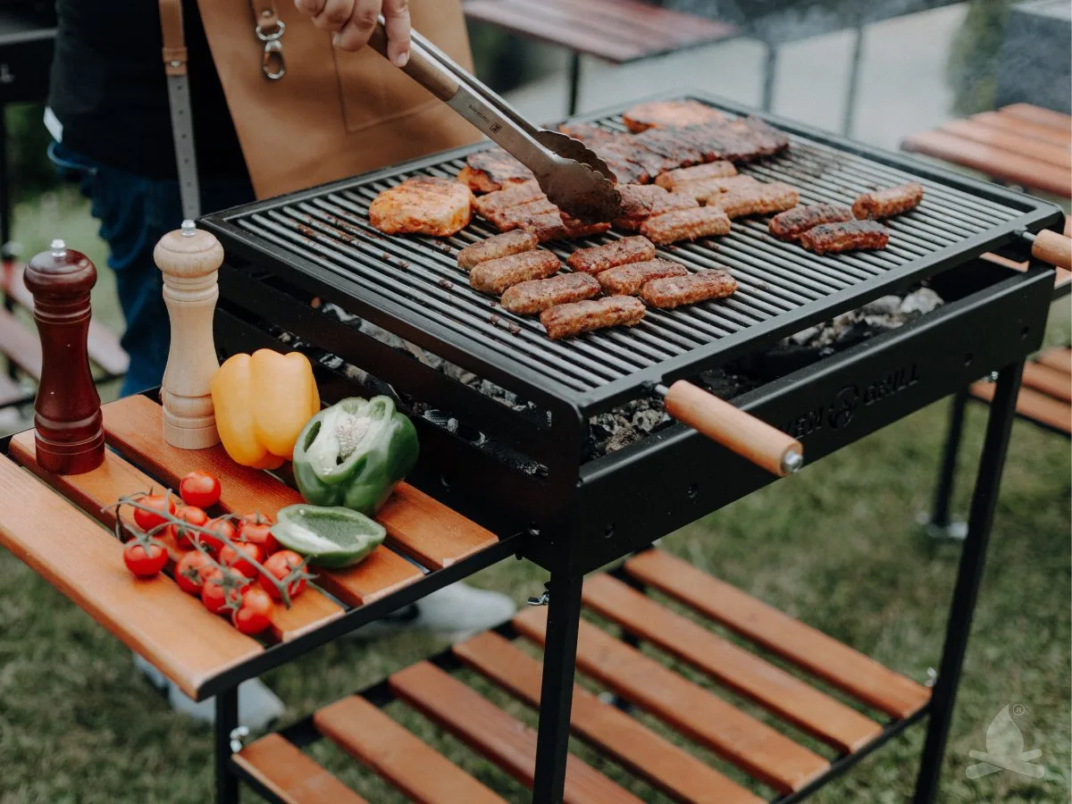 Grătar în curte cu diverse tipuri de carne și legume proaspete.