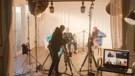 Un operator controlează mai multe camere într-un studio de înregistrare pentru podcasturi.