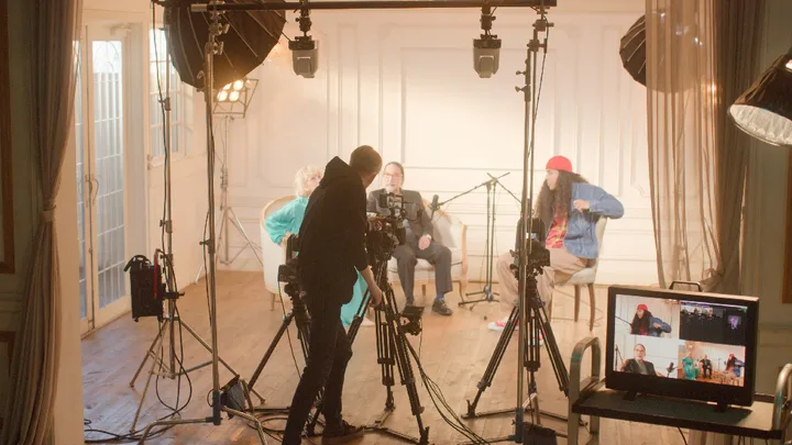 Un operator controlează mai multe camere într-un studio de înregistrare pentru podcasturi.