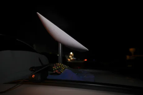 Antena Starlink montată pe un vehicul în noapte.