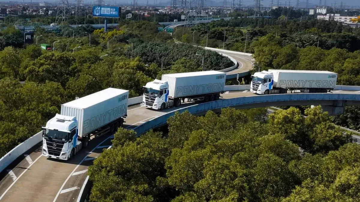 Coloană de camioane Sany circulând pe un drum modern, tehnologie avansată în acțiune.