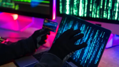 Un hacker folosește un laptop pentru a accesa date confidențiale.
