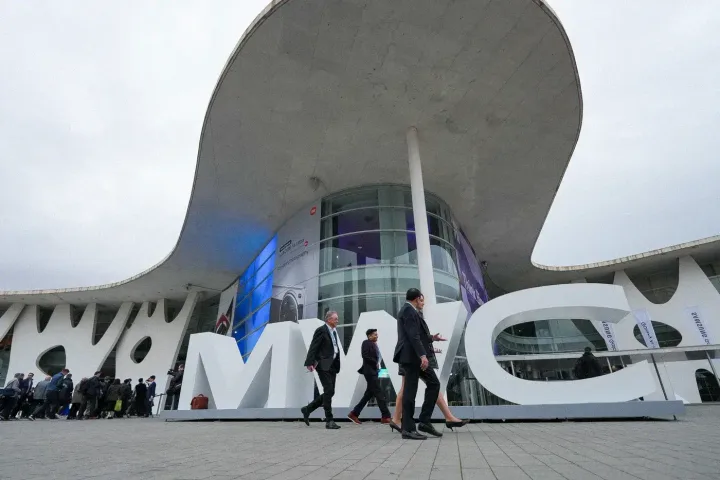Clădire modernă la MWC2026, cu participanți în fața ei.