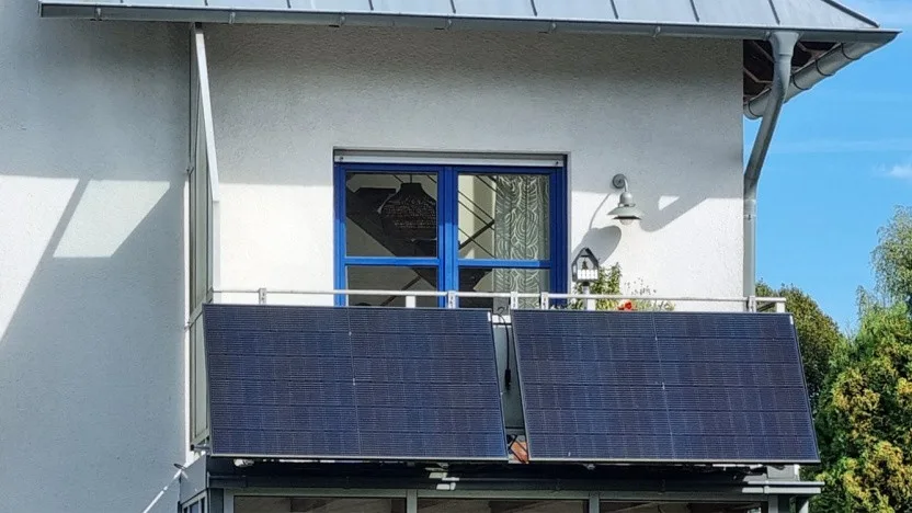 Sistem solar de balcon instalat pe o clădire din Germania, cu panouri solare vizibile.